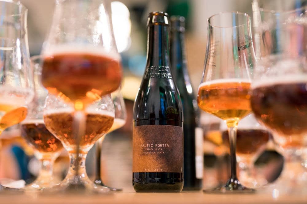 Botella de cerveza con copas servidas en Taberna Orgullosa.
